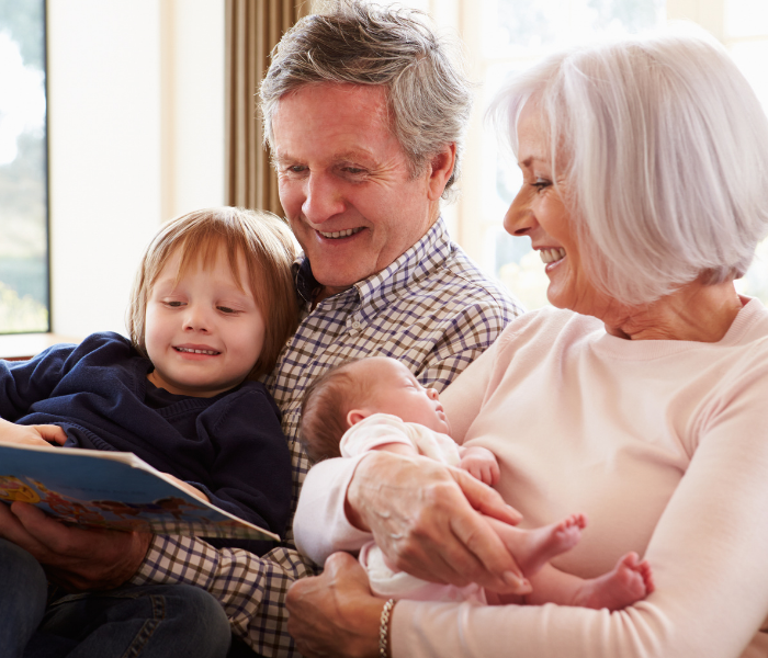 Grandparents reading a book with their grandchildren